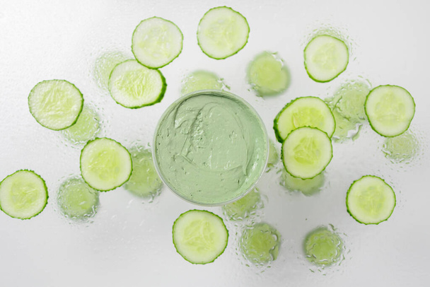 Handgemaakte bio natuur cosmetica met komkommer ingrediënten op een grijze achtergrond. Natuurlijke schoonheid en spa concept. Ruimte voor tekst - Foto, afbeelding