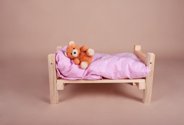 Ours en peluche dormant sur lit bébé
 - Photo, image
