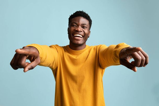 Charismatic african american man posing on blue, smiling and gesturing - Foto, Bild