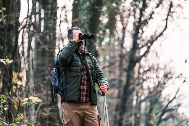 Image of man hiking and using binoculars. - Foto, afbeelding