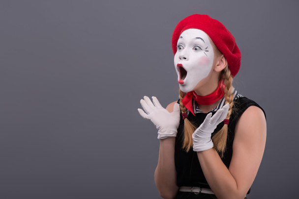 Waist-up portrait of young mime girl showing something - Fotografie, Obrázek