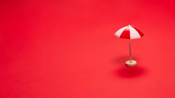 Κόκκινη ομπρέλα σε κόκκινο φόντο. Αντιγραφή χώρου. - Φωτογραφία, εικόνα