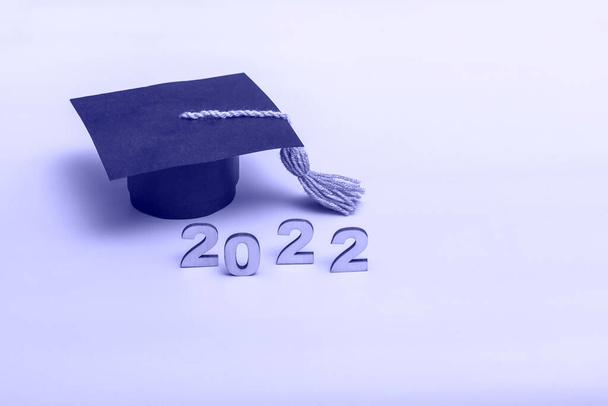 Cadeaudoosje in de vorm van een graduatiepet. 2022 release concept op zeer peri achtergrond met kopieerruimte - Foto, afbeelding