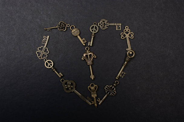 Retro metal keys form a heart shape om a black background - Фото, зображення
