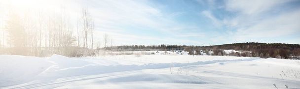 Kar fırtınasından sonra karla kaplı kırsal alanın panoramik görüntüsü. Taze karda insan izleri. Parlak bulutlu dramatik bir gökyüzü. Karelia, Rusya. Seyahat, eko turizm, çevre koruma - Fotoğraf, Görsel