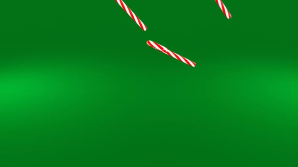 Animacja 4K 3D. Laski miętowe spadają powoli na zielone tło. Karmelki z trzciny cukrowej spadają i obracają się. Koncert świąteczny Bożego Narodzenia i Nowego Roku - Materiał filmowy, wideo