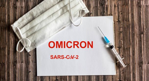 słowo omicron na notatniku z maską i szczepionką przeciw wirusowi korony. Omicron jest nowym typem wirusa korony pochodzącym z Republiki Południowej Afryki, oznaczonym jako B.1.529.. - Zdjęcie, obraz
