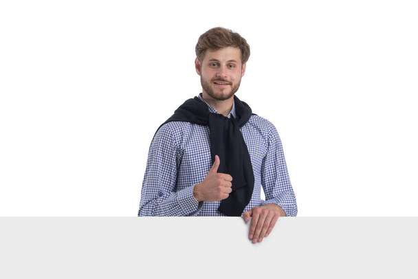 Young stylish casual business man behind a blank sign banner isolated on white background - Valokuva, kuva