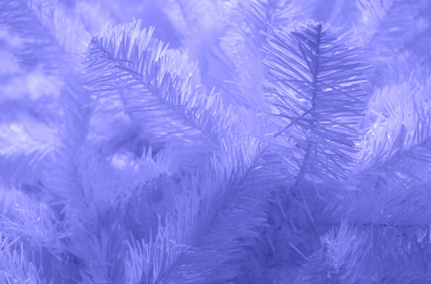 Close-up of artificial Christmas tree branches very peri color. Christmas holiday background. Copy space. - Foto, Imagem