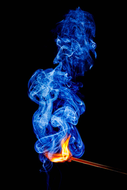 Flamme und Rauch eines Streichholzes auf schwarzem Hintergrund - Foto, Bild
