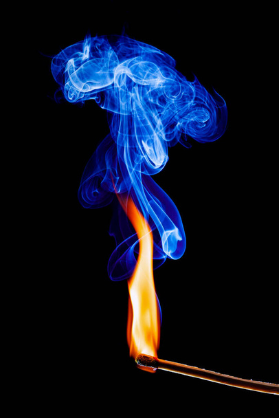 llama y humo de un fósforo sobre fondo negro - Foto, imagen