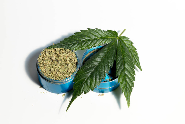 Marijuana Leaf and Cannabis Flower in Grinder, White Background - Photo, Image