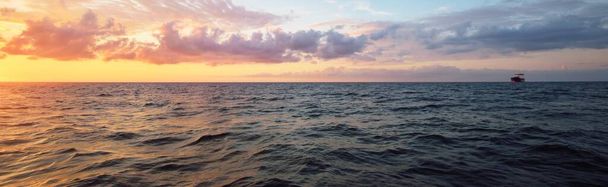 Kleurrijke gloeiende zonsondergang wolken boven de open zee, een uitzicht vanaf de zeilboot. Eenhandig zeilen op een 34 ft jacht. Engeland, Verenigd Koninkrijk. Dramatische zeegezicht. Reisbestemmingen, recreatie, reisgidsen - Foto, afbeelding