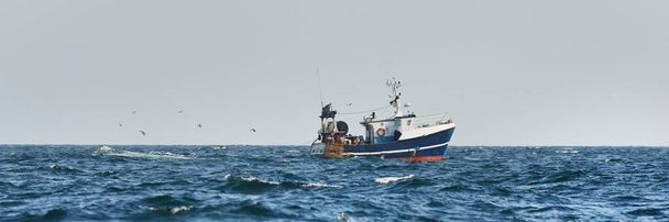 Kleines Fischerboot, das im offenen Mittelmeer segelt, aus nächster Nähe. Ein Blick von der Jacht. Freizeit, Sport und Freizeit, Lebensmittelindustrie, traditionelles Handwerk, Konzepte für Umweltschäden - Foto, Bild