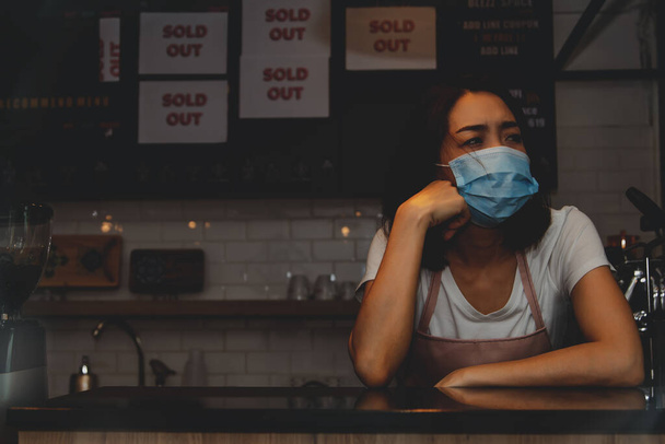 Der Stress eines Coffeeshops: Geschäftsfrauen haben Kopfschmerzen, Sorgen über Einkommen und finanziellen Stress, da die COVID-19-Epidemie ihre Geschäfte negativ beeinflusst hat: Copy Space. - Foto, Bild