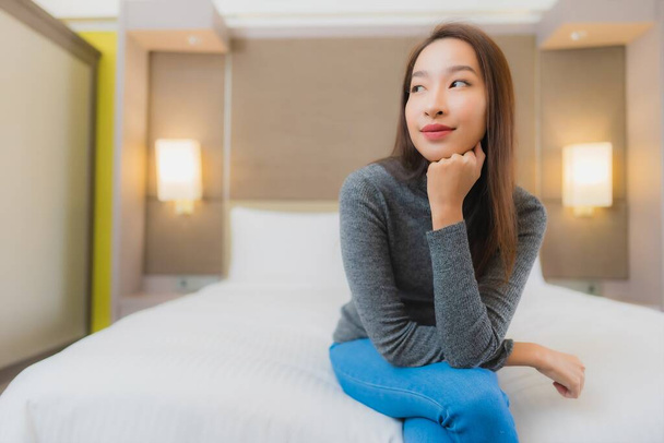 Retrato bonito jovem asiático mulher relaxar sorriso lazer na cama no quarto interior - Foto, Imagem