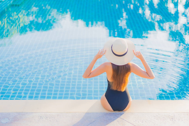 Retrato hermosa joven asiática mujer relajarse sonrisa ocio alrededor al aire libre piscina casi mar playa océano para vacaciones vacaciones - Foto, Imagen