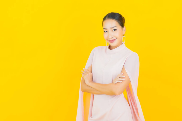 Portrét krásná mladá asijská žena úsměv s mnoha akce na žlutém pozadí - Fotografie, Obrázek