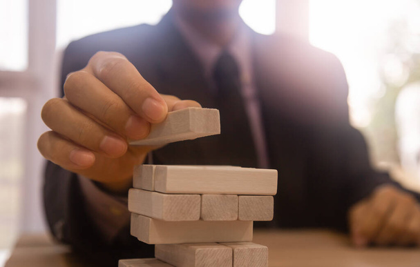 Business man gambling placing wooden block. Business concept  investment target and growth success process background present financial information planning, risk and marketing strategy analysis. - Foto, imagen