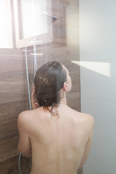 Nuori kaunis nainen suihkussa kylpyhuoneessa
 - Valokuva, kuva