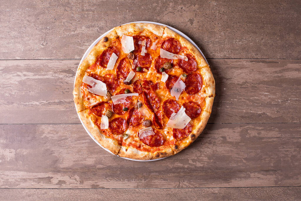 szczegóły świeżo upieczonej pizzy salami z oliwkami i płatkami parmezanowymi - Zdjęcie, obraz