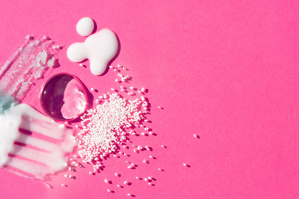 Cosmetic smears and drops. Appearance of the texture of the cream, oil and granules on a pink background. Natural skincare products. Beauty concept for face and body care - Photo, Image