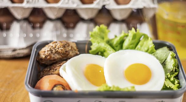 Μια εικόνα γκρο πλαν επιλεγμένο σωρό εστίασης αυγό τηγανητό με κρόκο στο κουτί με λαχανικά μια τροφή για πρωινό για υγιείς στο λευκό φόντο με αντίγραφο χώρο για το κείμενο. - Φωτογραφία, εικόνα