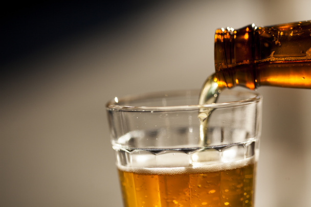 Birra versata dalla bottiglia al bicchiere in una giornata di sole. Foto di alta qualità - Foto, immagini