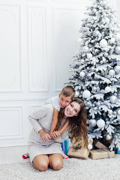 Anne ve oğul Noel ağacında hediyelerle. - Fotoğraf, Görsel