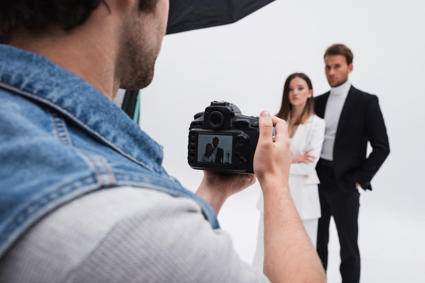 professional photographer taking photo of blurred models on white - 写真・画像