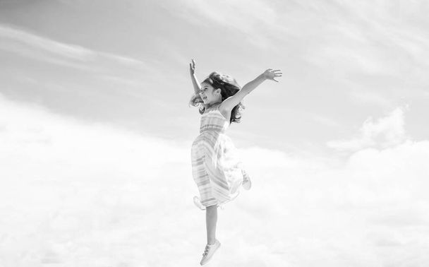 Forward to success. fashion and beauty. jumping and fly. smiling child with cheerful look. childhood happiness. pretty teenage girl in dress outdoor. kid summer fashion. cheerful and carefree - Foto, Imagem