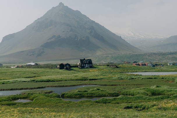 Field with a village at the base of Gatklettur Volcanic peak. . High quality photo - Photo, Image