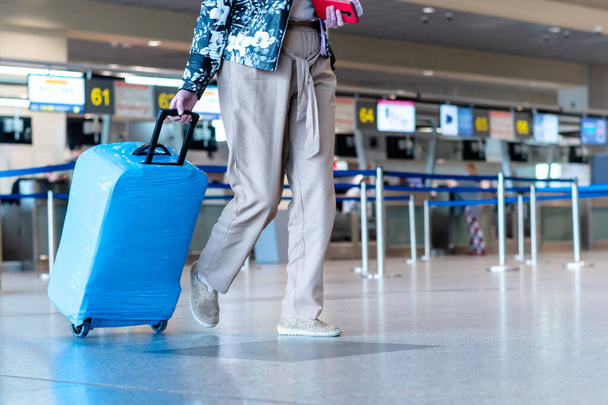people wearing medical masks walking with luggage bags suitcases at the airport travel concept - Valokuva, kuva