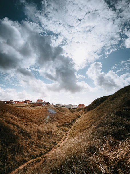 A vertical shot of village on a hilly terrain under a cloudy sky in the countryside - Photo, image