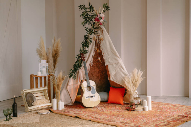 Photozone in the form of a tipi decorated in boho style with greenery - Foto, Imagem