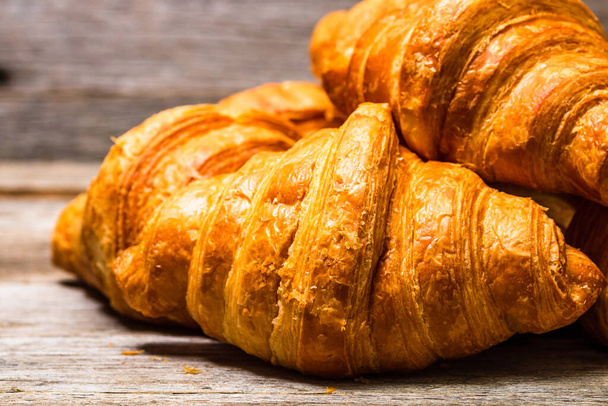 A closeup shot of tasty croissants on a wooden table - Photo, Image