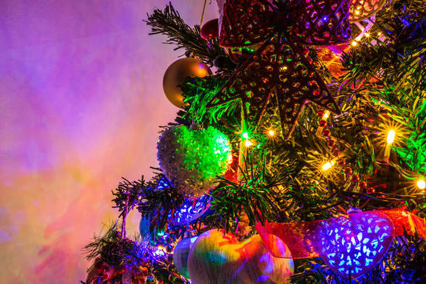 A closeup shot of a Christmas tree decorated with colorful lights and balls - Valokuva, kuva