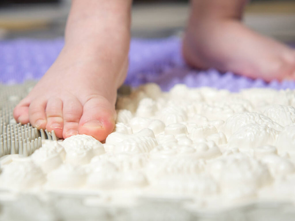 baby's feet on a children's orthopedic mat close-up - Fotó, kép