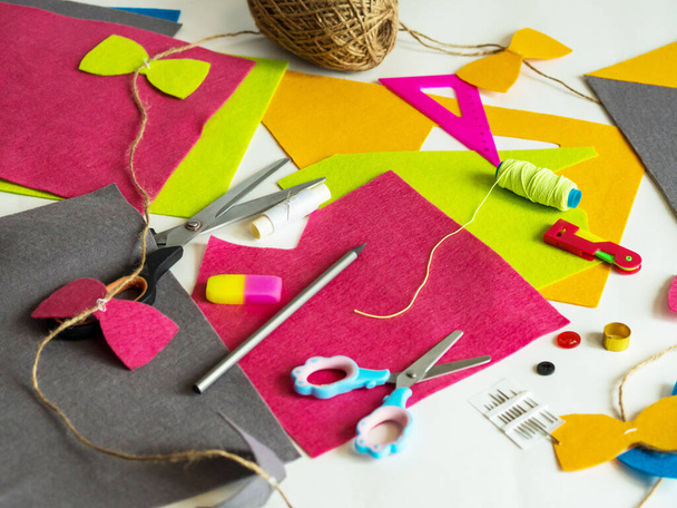 Hobby and colorful felt crafts. Workspace view. Sheets and crafts made of felt, scissors, threads and a needle for needlework. - Foto, Imagem