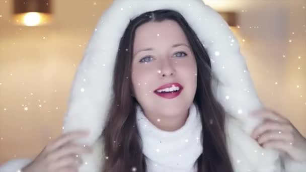 Moda de invierno y look navideño. Hermosa mujer sonriente con suéter blanco y abrigo de piel con capucha esponjosa, nevando nieve y copos de nieve - Imágenes, Vídeo