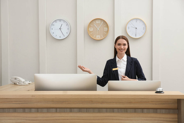 Portrait of beautiful receptionist at counter in hotel - Φωτογραφία, εικόνα