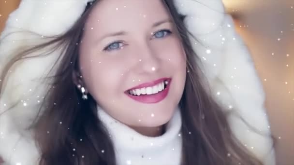 Moda invernale e look natalizio. Bella donna sorridente che indossa maglione bianco e soffice pelliccia con cappuccio, neve nevosa e fiocchi di neve - Filmati, video