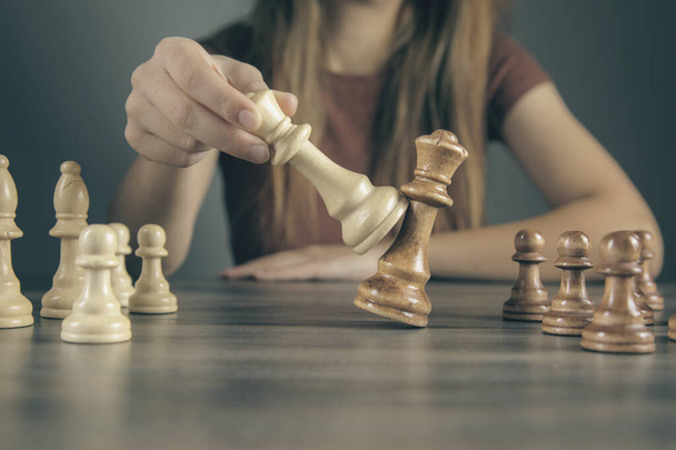 donna da sola gioca con pezzi di scacchi - Foto, immagini