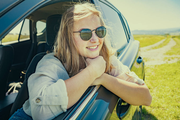 uma jovem em um carro na viagem rural
 - Foto, Imagem