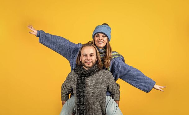 lets fly together. cheerful couple in love. romantic relations of man and woman in winter. love can warm us. new year holiday and vacation. cozy and comfortable. knitwear fashion for all family - Photo, image