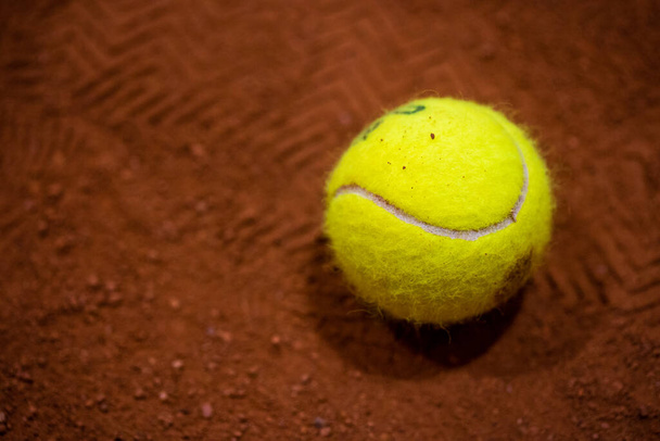 Теннисный мяч на теннисном корте. Гравий. Теннисная игра. Спорт, концепция отдыха - Фото, изображение