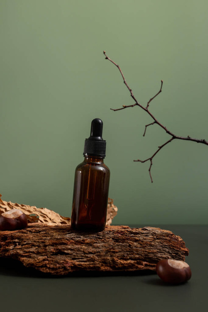 Ruskea lasipullo kosmeettista valmistetta tai öljyä puuta ja paperia vihreällä pohjalla. Natura Spa Kosmeettinen kauneus käsite, ekologia ja luonnon kauneus - Valokuva, kuva