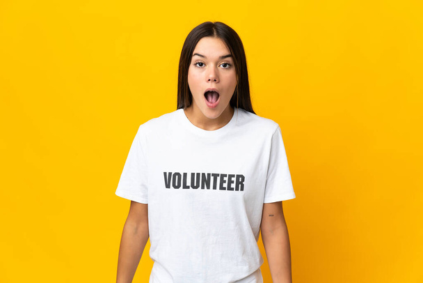 Teenager volunteer girl with surprise facial expression - Foto, Imagen