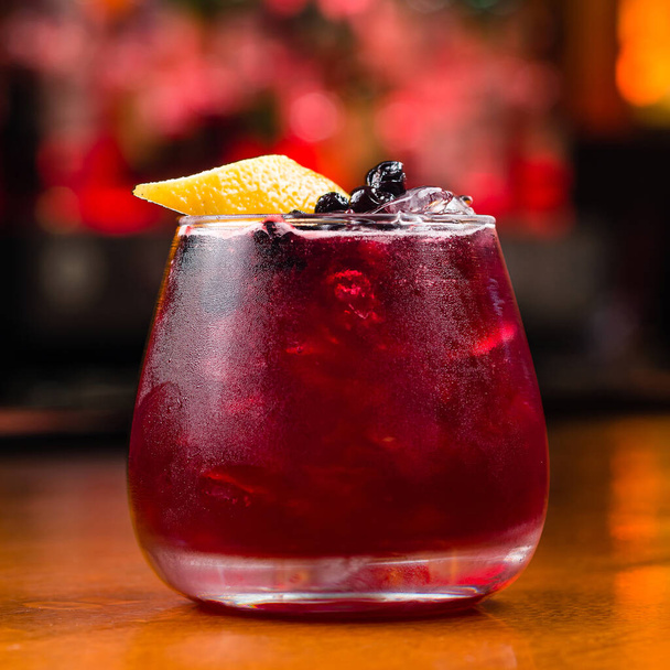 red cocktail with fresh berries and lemon slice. Fresh red water with lemon and blueberries. Exotic summer drink with citrus slices. Red berry or fruit lemonade - 写真・画像