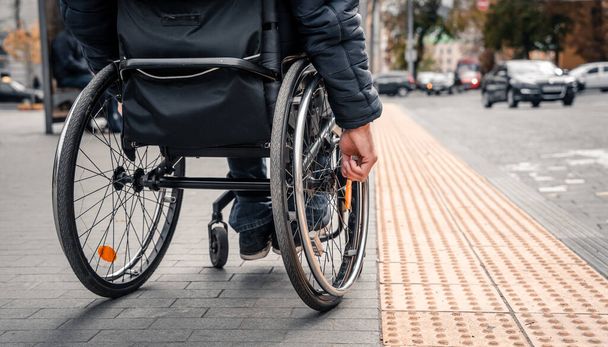 Person with a physical disability waiting for city transport with an accessible ramp. - Φωτογραφία, εικόνα